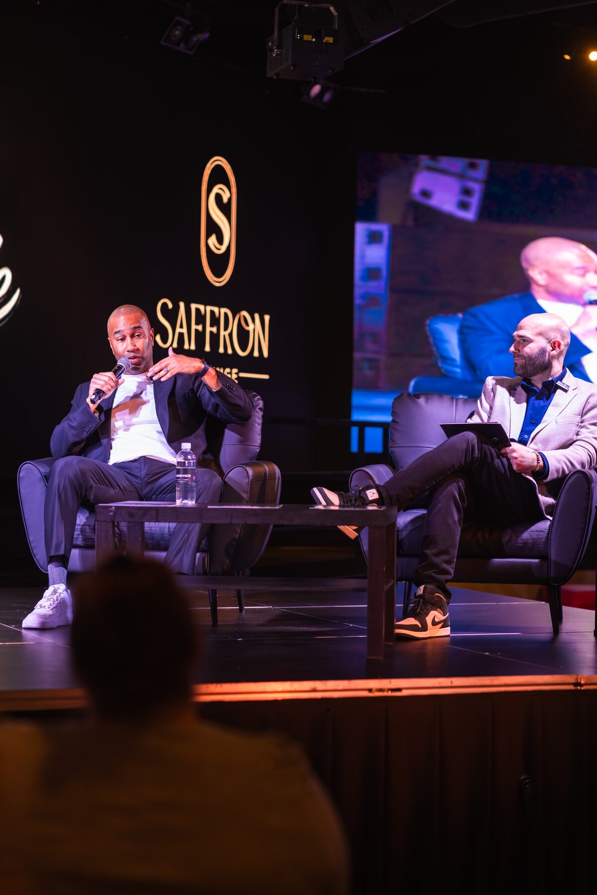 Paki Phillips on stage at a live podcast event